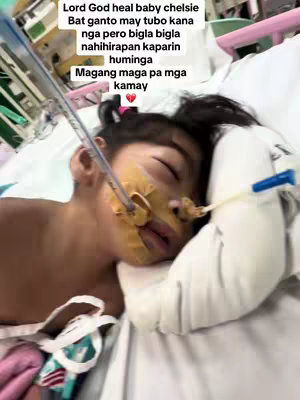 A sick child lies in a hospital bed with medical tubes and devices attached. Text overlays in Filipino are set against the child's face.