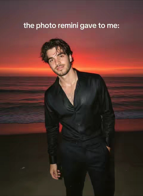 A man stands on a beach at sunset. He is wearing a black button-down shirt and black pants. The sky is ablaze with red and orange hues, and the ocean is visible in the distance. The headline, 'the photo remini gave to me:' is written in a white font at the top.