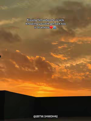 The image captures a dramatic sunset with a primarily orange and yellow color palette. The sky filled with clouds, with the bottom section of the image showing a dark area, possibly a rooftop or a similar structure. Text overlay is present.