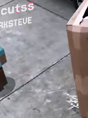 The image shows a close-up of a Minecraft-style character's foot on a sidewalk. There's also a box in the shot, suggesting something was delivered or is being moved. Text overlays are present at the top left. The overall scene appears to be a humorous take, perhaps related to a mishap or a misplaced item.