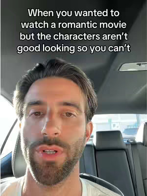 A man with brown hair and a beard is inside a car, looking directly at the camera. Text overlays the image.