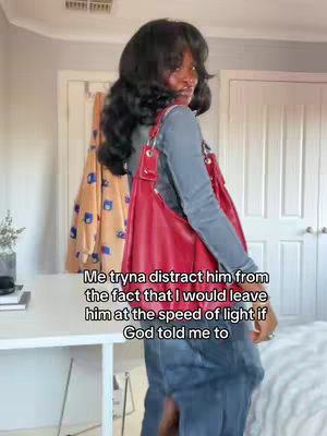 A woman with long dark hair is shown in a side profile, wearing a gray long-sleeve shirt and blue jeans, holding a large red bag. She appears to be in a home setting with white doors and a closet visible in the background. Text overlayed on the image reads, "Me tryna distract him from the fact that I would leave him at the speed of light if God told me to."