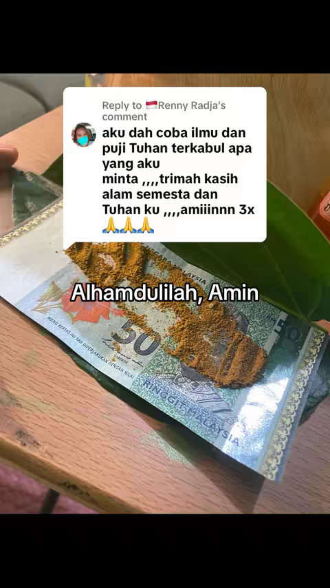 The cover image shows a Malaysian 50 Ringgit note with a layer of brown powder spread on it. On the top left corner there is a comment overlay from a social media with some text and user's avatar. Above the Malaysian Ringgit, there is a larger text overlay "Alhamdulilah, Amin". The composition is a top-down view with a wooden table background.