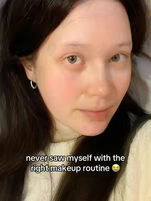 The image shows a close-up of a young woman's face, looking at the camera. She has dark hair and is wearing a white top. Text overlayed at the bottom of the image reads: 'never saw myself with the right makeup routine 🥺'.