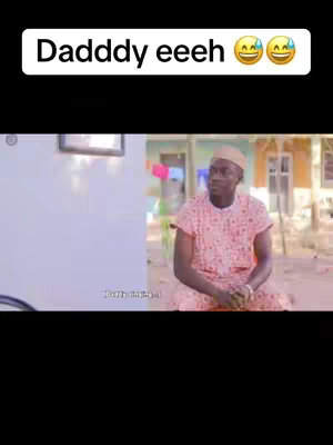 A still image from a video showing a Black man sitting outside. The man is wearing a pink patterned short-sleeved shirt, a white cap, and is looking to the side with a slight frown. The background contains a white wall, a building with a window, and some trees, suggesting an outdoor setting. The text overlay indicates the subject of the video, and the emojis reflect the mood.