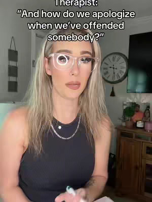 The image features a woman in a well-lit room, likely a therapist's office. She has blonde hair, wears clear-framed glasses, and is dressed in a black tank top. Behind her, a clock and a cabinet are visible, suggesting a professional setting, and text overlay presents a question about apologizing, indicating content related to relationship advice or therapy.