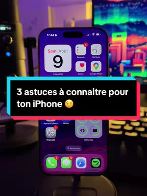 The cover image shows two iPhones stacked, with one in focus. The top phone displays the home screen with the date, a clock, and the usual app icons. A black text box with white text overlays the phones, advertising "3 astuces à connaitre pour ton iPhone". The background is a blurred setup with a purple and green lighting setup.