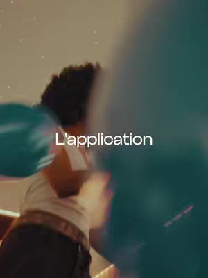 The cover image is an artistic shot focusing on a person, likely in a party setting. The individual's body is partially visible, with a blurred backdrop suggesting movement and celebration. The person appears to be holding a large blue balloon, which takes up a significant portion of the frame. The lighting appears to be festive, with a sense of motion and energy. The color palette is cool, with muted tones, creating a vibrant yet slightly obscured visual. The text overlay 'L'application' is prominently displayed in the image.