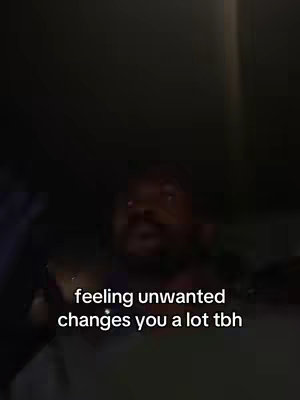 The cover image shows a man in an indoor setting, likely a car, in a medium shot. The man's face is visible, and he appears to be looking slightly off-camera while talking. Text overlaid on the image states, "feeling unwanted changes you a lot tbh". The lighting is dark, casting shadows, which creates a sense of pensiveness. The overall composition focuses on the man's expression and the overlaid text.
