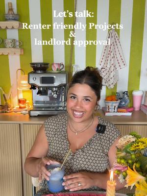 A woman smiles at the camera holding a blue-tinted beverage in a glass with a straw, set against a backdrop of green and white striped wall and a kitchen counter with a coffee machine. Text overlay reads 'Let's talk: Renter friendly Projects & landlord approval'.