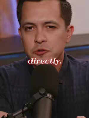 The cover image of the video shows a man looking directly at the camera, against a blurred background. The man is wearing a dark, patterned button-down shirt and has short, dark hair. In the image, a microphone is positioned near his mouth. Text in a cursive font that reads "directly." is overlayed in red on the middle-bottom of the image.