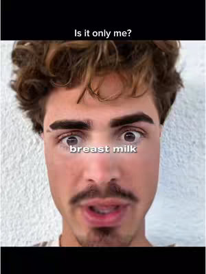 A close-up shot of a man with a surprised expression. He has brown curly hair, thick eyebrows, and a mustache. The text overlay says "breast milk".