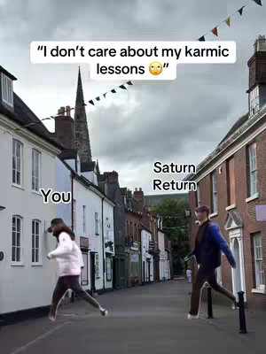 An image in a vertical smartphone format shows two stick figures running away from each other down a street in a European-style city. Above, text reads 'I don't care about my karmic lessons 🙄'. The figure on the left is labeled 'you' and appears to be female, while the figure on the right, labeled 'Saturn Return', is male. Buildings line the street.