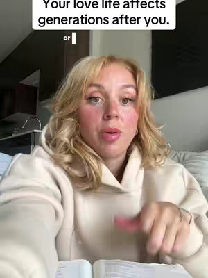 A woman with blonde hair wearing a beige hoodie is speaking to the camera. Above her head is a text overlay, and in front of her appears to be an open Bible.