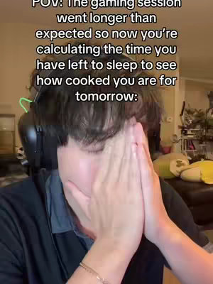A young man is captured in a close-up shot, covering his eyes with his hands, conveying a sense of distress or embarrassment. Above his head, text overlays detail a scenario related to a gaming session that extended too long, with the implication that the individual is calculating the amount of sleep they will get. The setting seems to be indoors, suggested by elements of background and the immediate environment.