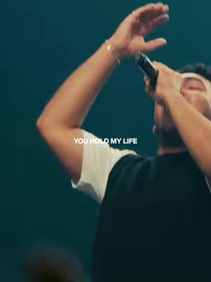 The cover image shows a man with his arm raised holding a microphone. The text 'YOU HOLD MY LIFE' appears in white over the image.