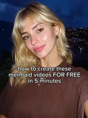 A portrait-style shot of a young woman with blonde hair, positioned against a blurred background of city lights and a dark sky. She's gazing slightly off-camera with a soft smile, wearing a brown top, and the image has text overlay in the bottom. The overall aesthetic is well-lit, with a warm tone.