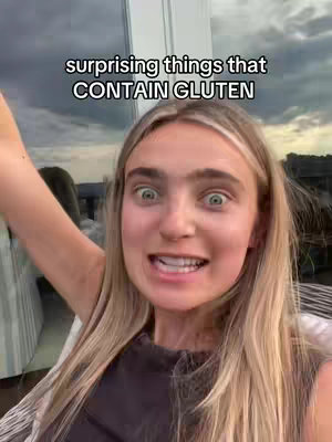 A selfie-style shot featuring a young woman with blonde hair, wide eyes, and an expression of surprise. The background includes a window with a blurred outdoor view.