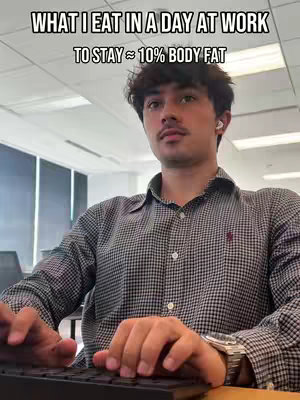 A man sits at a desk with his hands on a keyboard, looking toward the camera. Text is superimposed on top of the image.