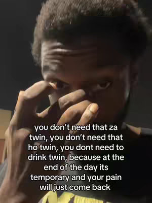 A close-up shot of a young Black man with a dark complexion. His face is partially obscured by his hand, as if he is wiping away tears or covering his eyes. The background is dark, and text overlays the image.