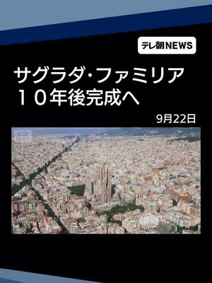 The image shows a wide aerial shot of a city with the Sagrada Familia church prominently featured in the center. Text overlays in Japanese indicate the video's topic and completion timeline.