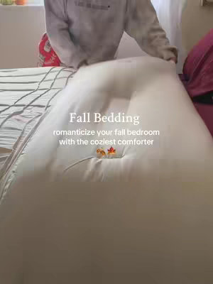 The cover image shows a person inside of a room, with a bed and a patterned quilt, arranging a white comforter. The title overlayed onto the image is in a white font. The image appears to be brightly lit.
