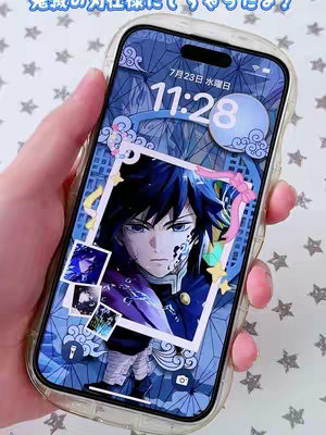 A hand holding a smartphone with a clear case. The phone's screen displays an anime-style graphic with a character, the date, and time appearing at the top. The background is a pale blue color sprinkled with light grey asterisk shapes. The hand is holding the phone above a surface that resembles a white table or counter, with pink nail polish visible.