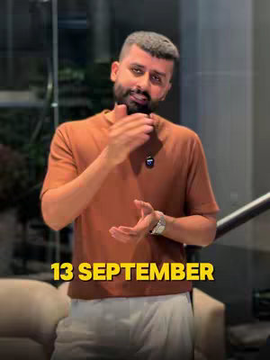 A man in a brown t-shirt is standing and gesturing with his hands. The text overlay in yellow color reads '13 SEPTEMBER'. The setting seems to be indoors with stairs in the background.