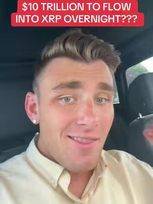 A selfie-style shot of a man inside a car. Overlaid at the top in a red box is the text: '$10 TRILLION TO FLOW INTO XRP OVERNIGHT???'. The man is fair-skinned with short, styled brown hair and light eyes. He’s wearing a light-colored button-down shirt and has a small earring in his left ear. He has a slightly open mouth and a smirk, perhaps expressing excitement. The background is somewhat blurred, but you can see parts of the car interior.