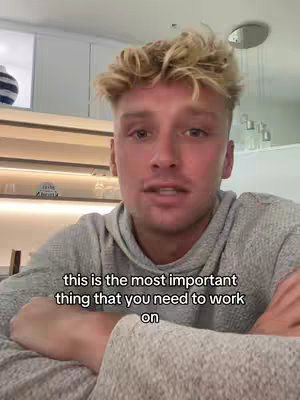 A close-up shot of a young man with blond, tousled hair, speaking directly to the camera. He's wearing a gray hoodie, and the background suggests an interior setting with neutral tones. Text at the bottom of the image reads, 'this is the most important thing that you need to work on'.