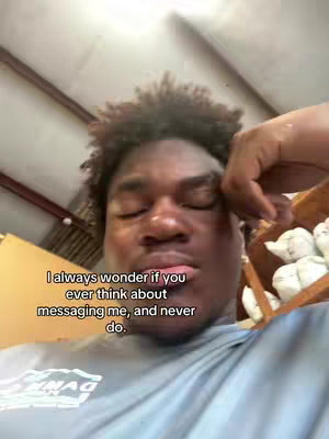 The cover image shows a close-up of a dark-skinned man looking at the camera with a slightly downward gaze and a pensive expression. He is wearing a gray t-shirt, and his right hand is resting near his head. Behind him, the image shows a partially visible, cluttered space with various objects hinting at an interior setting, possibly a workshop or storage area. Text overlaid on the image poses a question about someone messaging the viewer, underscoring the expressive focus on the person's face.