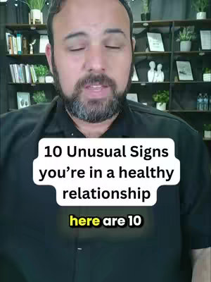 A man with a beard is centered, looking towards the camera. Overlaid on him are text boxes with video titles, and blurred shelves fill the background.