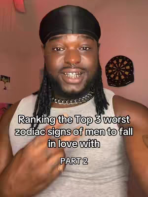 A man with a black durag, gold teeth, and a silver chain necklace is centered in the frame. Text overlays his chest, and a dartboard hangs in the background, along with a shelf of random things that appear to be in a bedroom setup. The overall tone is casual and direct.