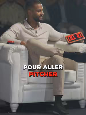 A man in a beige sweater sits on a white armchair, holding a device showing '00:10'. Text on the image reads 'POUR ALLER PITCHER'. The background is blurred, suggesting a studio setting.