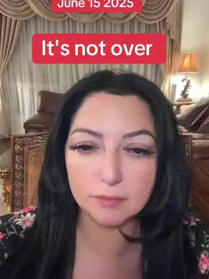 A woman with long black hair gazes downward, framed from the upper chest up. Above her head is a red rectangle with the text 'It's not over,' and above that is a smaller rectangular text that says 'June 15 2025'. The background is a blurred interior with curtains, furniture, and a lamp.