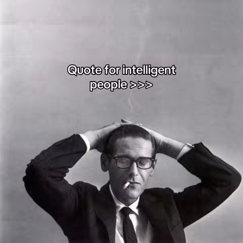 A black and white photo features a man with glasses and a suit, holding his head in his hands. Quote text overlayed.