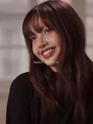A selfie-style shot of a young woman with dark hair and a smiling expression. The text overlay 'march ARIES vs.' is at the bottom.