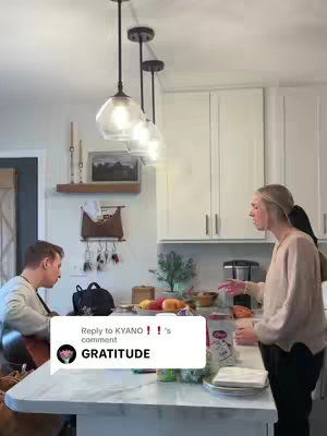 A kitchen scene with a person playing a guitar and a person gesturing in conversation. A speech bubble with text is superimposed.