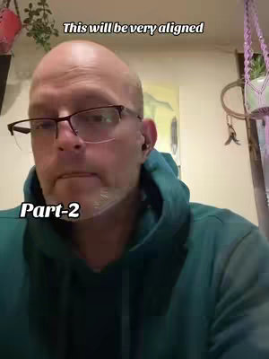 A bald man wearing glasses and a green hoodie is looking at the camera. The text overlay says 'This will be very aligned' and 'Part-2'. The background features a wall, a plant, and hanging decor.
