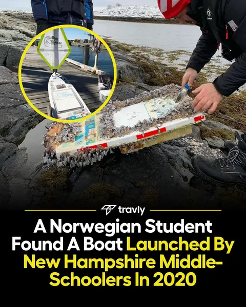 The image shows a mini boat covered in barnacles being examined by two people on a rocky shoreline. The boat, which has some design or artwork present, is situated near the water's edge with a partially visible pier and water in the background. Text overlays at the bottom name the publishing company and the video's context.