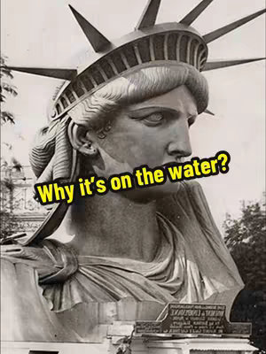 A black and white close-up of the Statue of Liberty's head and shoulders. The statue is looking to the viewer's right, with a text overlay in a yellow rectangle that reads 'Why it's on the water?'.