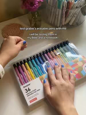 The cover image shows a person's hands holding a package of colored pens, likely for testing. The background is a desk setup.