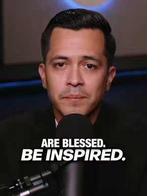 A man with short dark hair and a dark suit is centered in the frame. He has a serious expression and is looking directly at the camera. A microphone obscures the lower half of his face. The background is dark, and text overlays are positioned at the bottom. The overall composition uses a standard portrait framing.