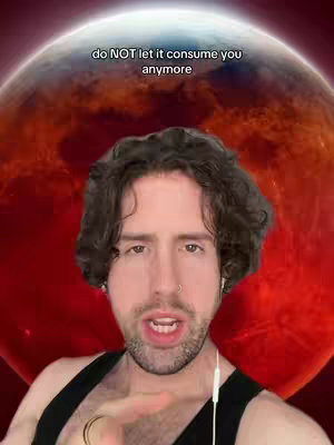 A man with short brown hair and a ring through his nose is centered in the shot, slightly angled. Behind him is a red, planet-like globe with cloud-like texture. He is wearing a black tank top and has earbuds in. A text overlay is visible at the top.