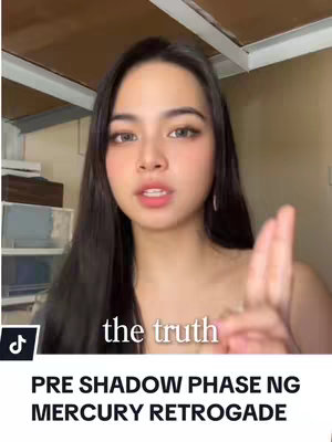 A young woman with long dark hair is centered in the frame, her gaze directed towards the viewer with a neutral expression. She is holding up a hand in a gesture, and the background appears to be a simple interior, likely a room. Text overlays the image. The overall composition conveys a sense of direct address, suitable for communication.