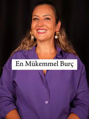 A woman with blonde hair smiles, wearing a purple button-down shirt and gold earrings. A white rectangle with the words "En Mükemmel Burç" in black text is overlaid near the bottom. The background is dark.