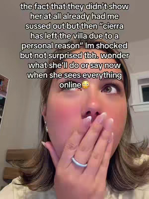 A close-up shot of a woman reacting with shock. She covers her mouth with one hand, while her eyes are wide and looking up. The image has text overlayed, with a caption about a reality TV show.
