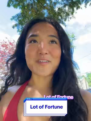 A woman with long black hair looks upwards with a dreamy expression under trees. Overlayed text reads: "Lot of Fortune". A light blue and white box with a blue outline holds the text.