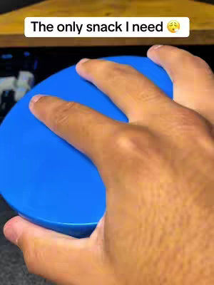 A hand holding a bright blue lid against a darker background, with text overlayed on the top