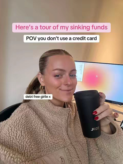 The cover photo shows a woman sitting and holding a black mug. Text overlays read "Here's a tour of my sinking funds" and "POV you don't use a credit card". The woman is fair-skinned with blonde hair pulled back, wearing a textured tan jacket. The background includes a blurred computer screen. The overall composition is well-lit and casual. The colors are neutral and the layout is simple, focusing on the creator.